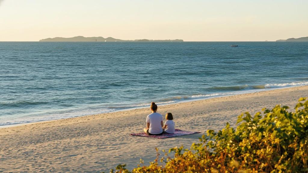 two people sitting on the beach looking at the ocean at Boryeong (Daecheon) Jeil Pension in Boryeong