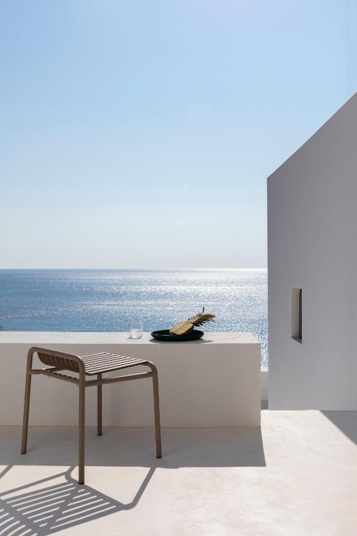 a table and a chair in a room with the ocean at Seriphos Estate in Serifos Chora