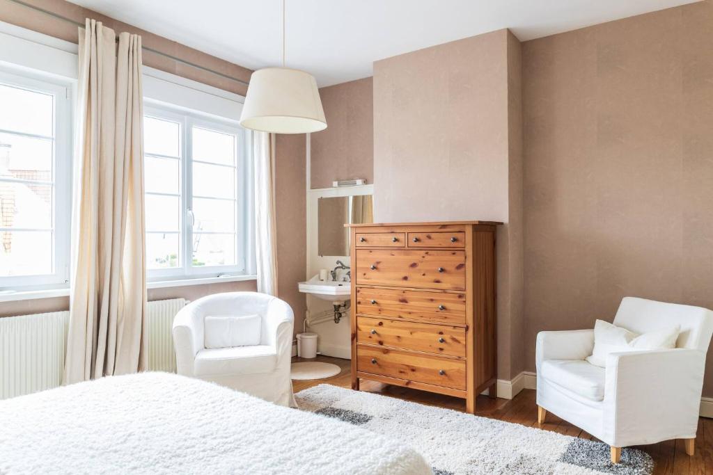 a bedroom with a bed and a chair and a dresser at Maison familiale quartier Quentovic in Le Touquet-Paris-Plage
