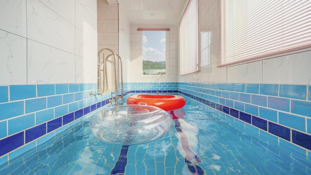 a bathroom with a toilet in a swimming pool at Gapyeong Ribbon Spa Pool Villa in Gapyeong