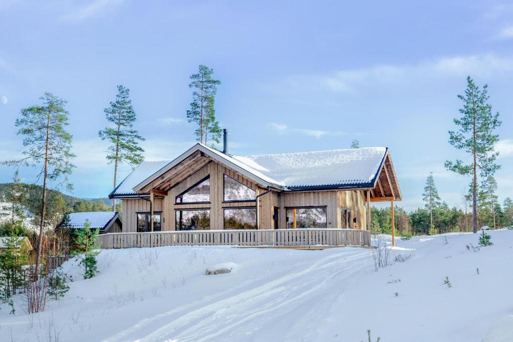 a log home in the snow with a fence at Sigr Hytte 8p With Sauna in Vradal