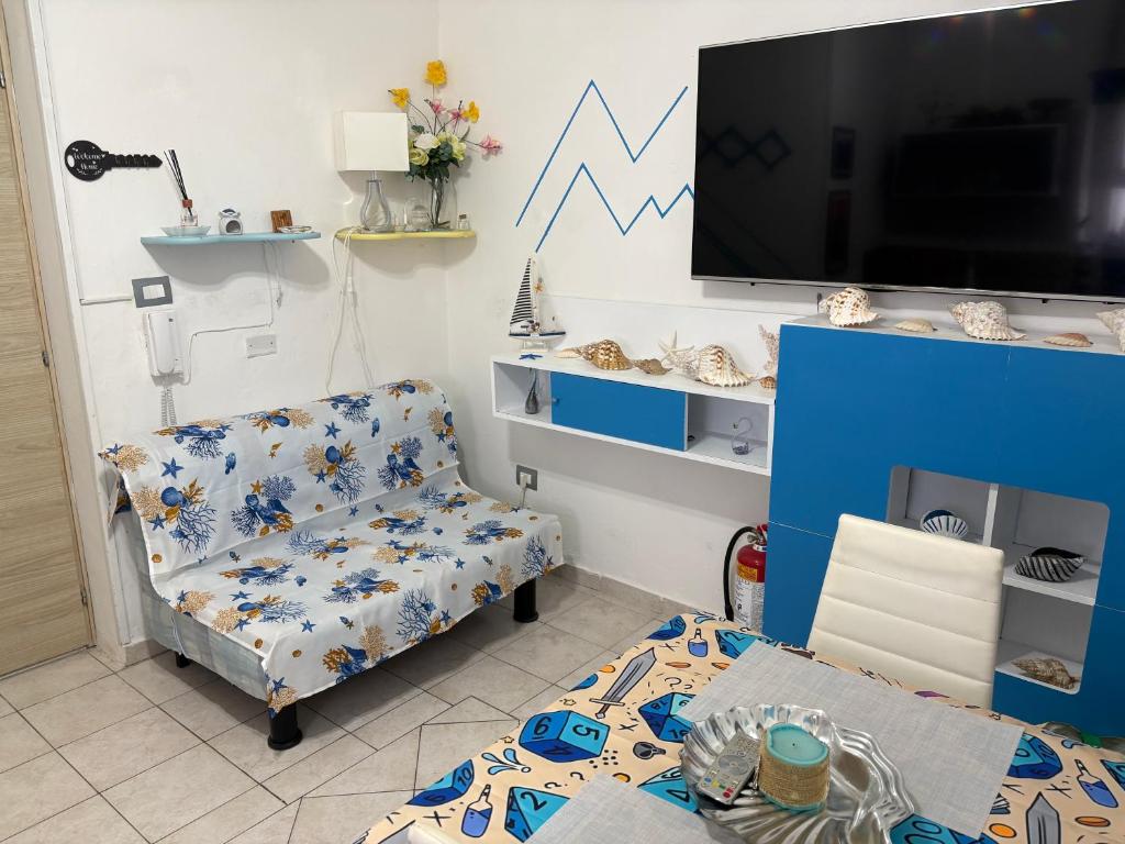 a living room with a chair and a tv at La Stanza del Mare in Calasetta