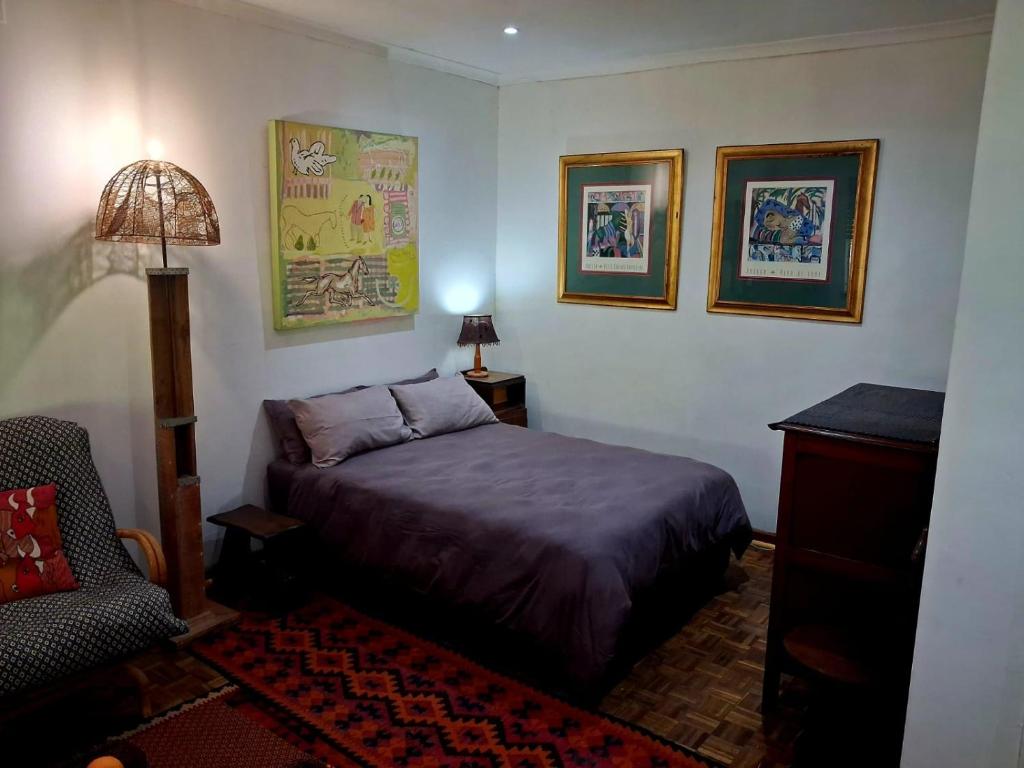 a bedroom with a bed and a chair at Pennywhistle in Eersterivier