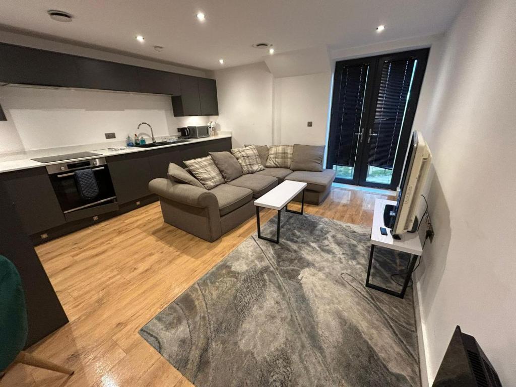 a living room with a couch and a kitchen at The Courthouse Stylish Serviced Living in Ramsgate