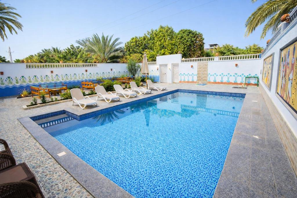 a swimming pool with lounge chairs and a swimming pool at Astralis Hotel - Hot Air Balloon View in Al Aqālitah