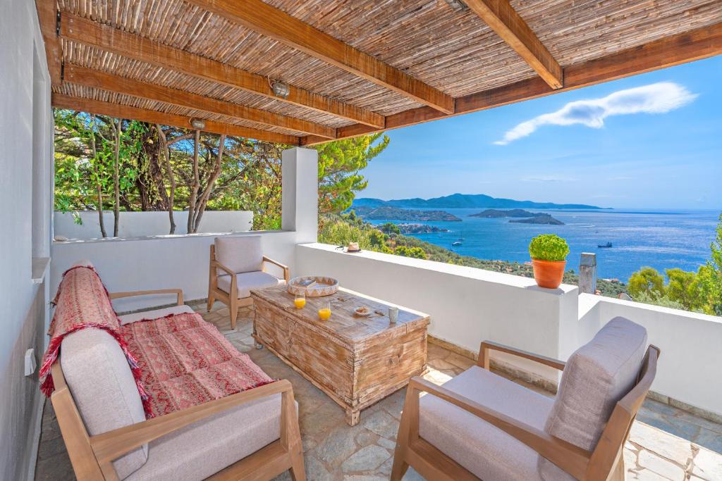 a patio with a table and chairs and a view of the ocean at Villa Cleio where the sea meets absolute calm in Skiathos