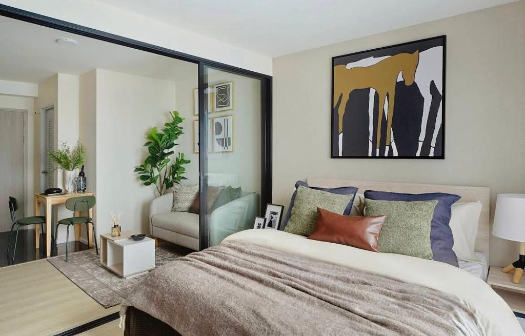 a bedroom with a large bed and a chair at Mega Bangna Studio Retreat in Bang Kew Yai