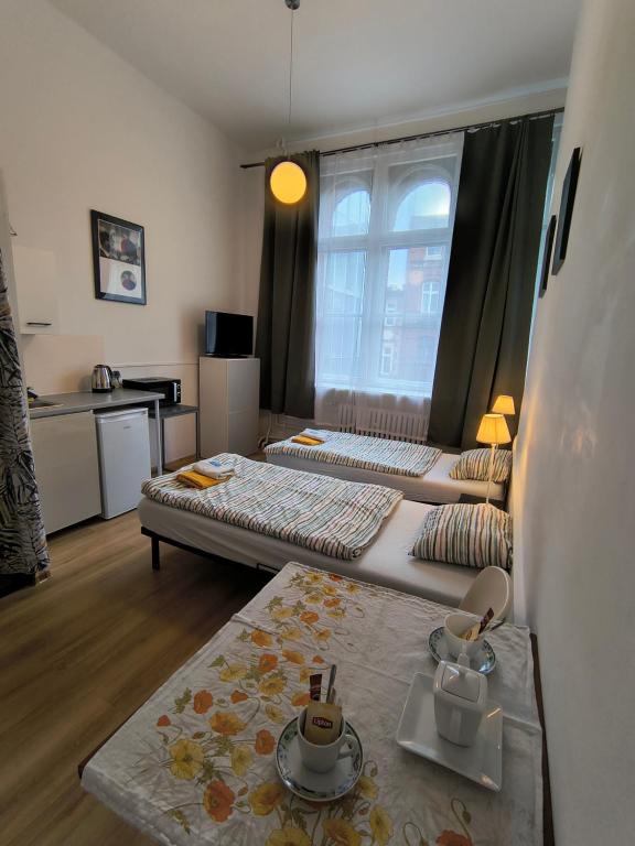 a living room with two beds and a table at U Szermierzy in Wrocław
