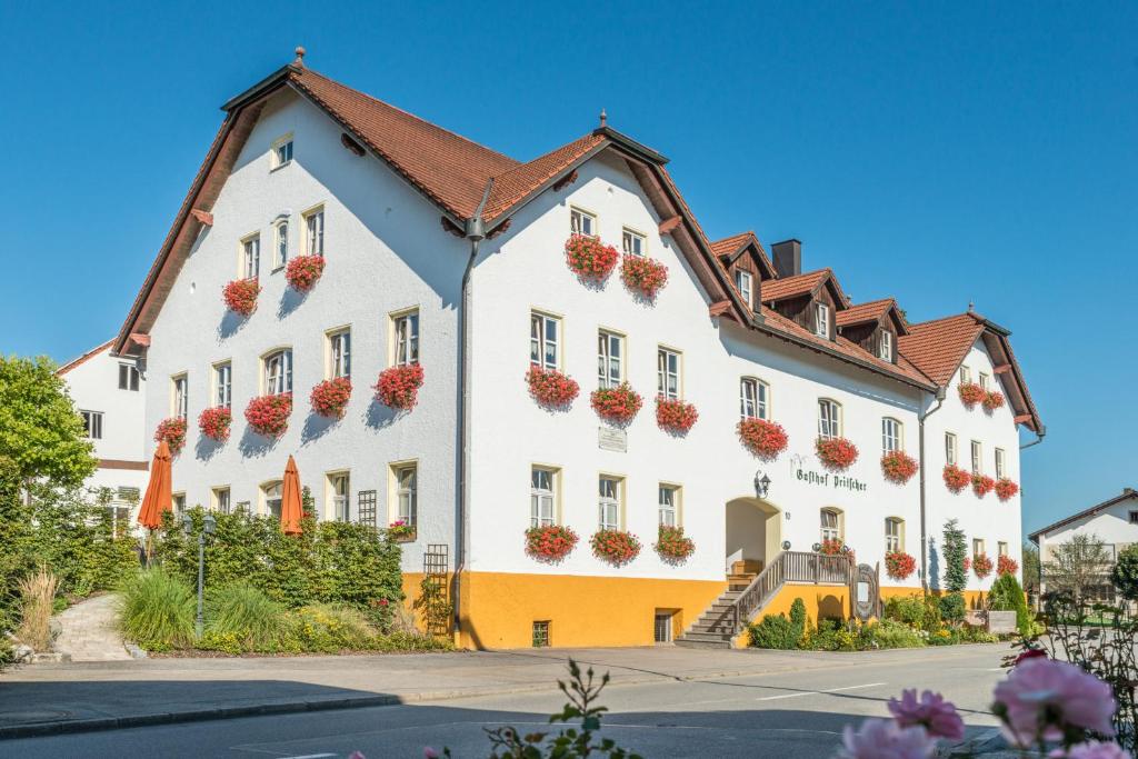 ein großes weißes Gebäude mit Blumentopfen darauf in der Unterkunft Gasthof Pritscher in Greilsberg