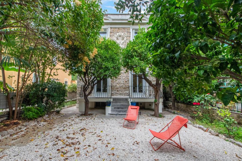 two red chairs sitting in front of a house at Happyfew maison Michelet in Nice