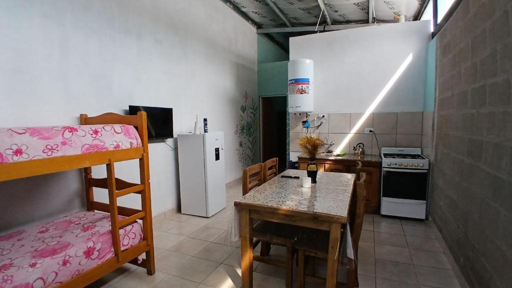 a small kitchen with a table and a refrigerator at La Casita de Junín in Junín