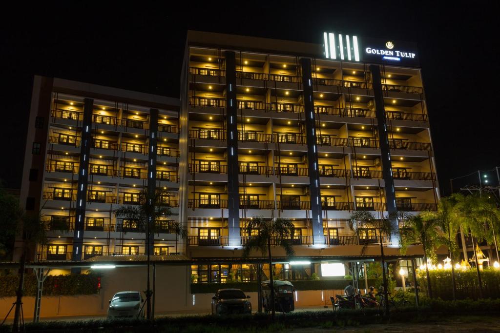un edificio iluminado por la noche en Golden Tulip Essential Pattaya en Pattaya North