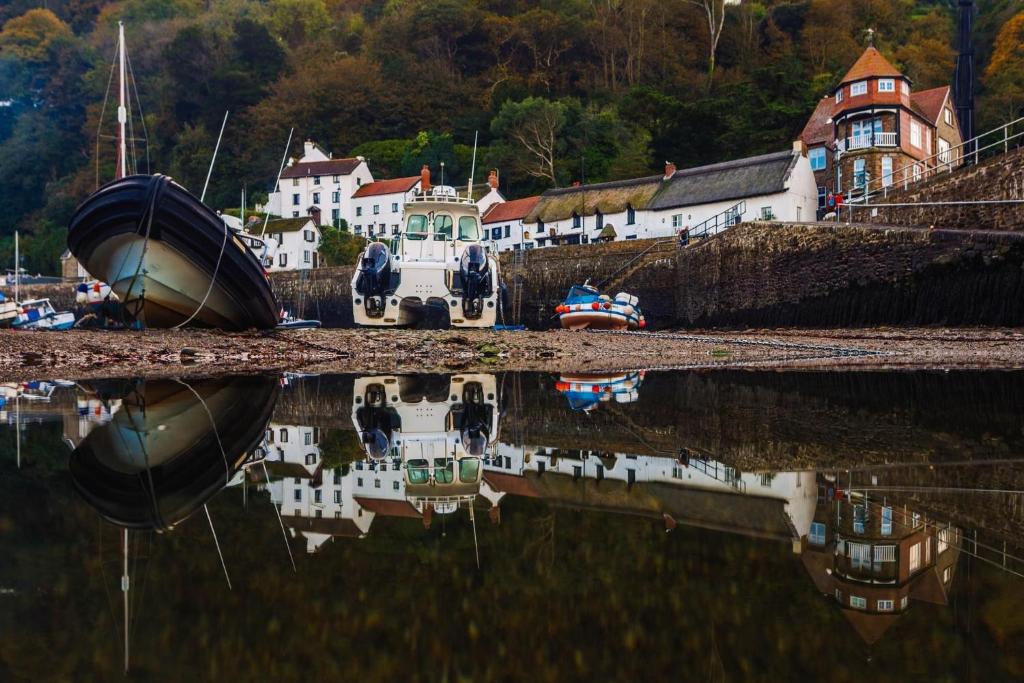 a group of boats are sitting in the water at Rising Sun Hotel in Lynmouth