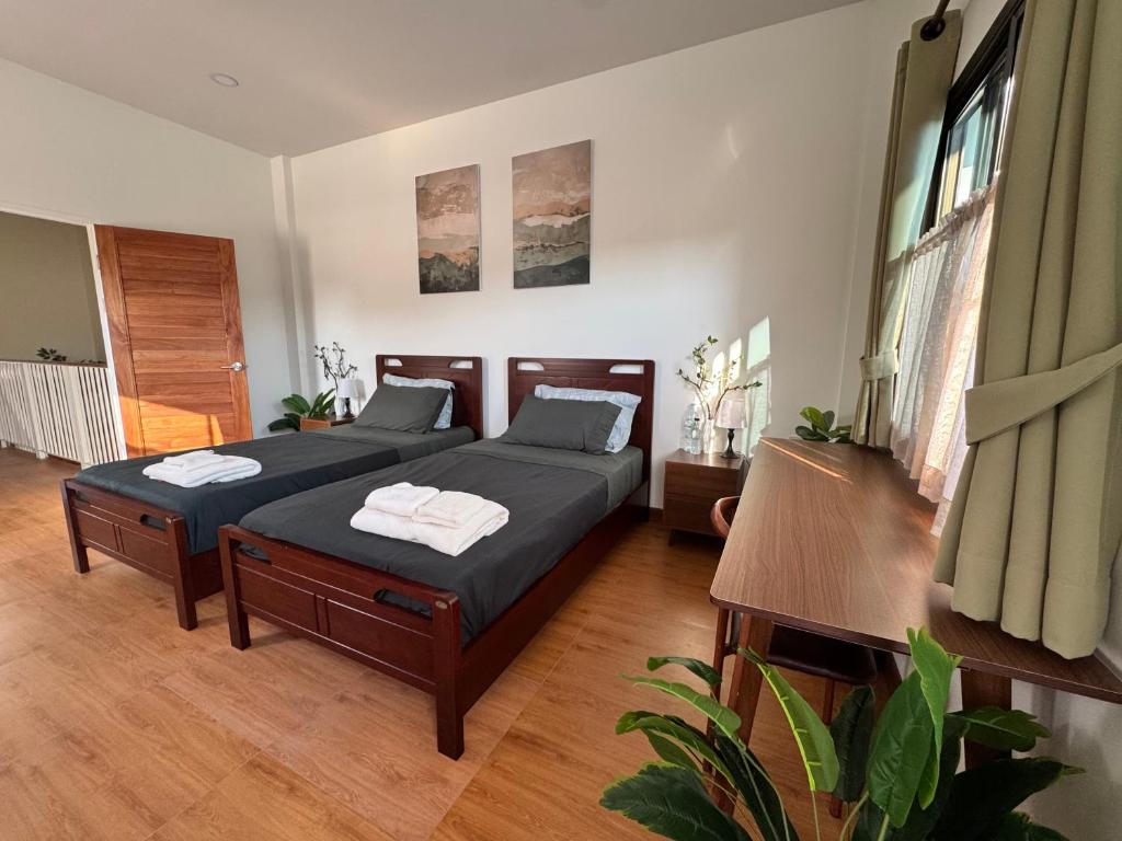 a bedroom with two beds and a table at Nong Hoi Nest, New Townhome with Positive Pressure Air Purifier in Chiang Mai