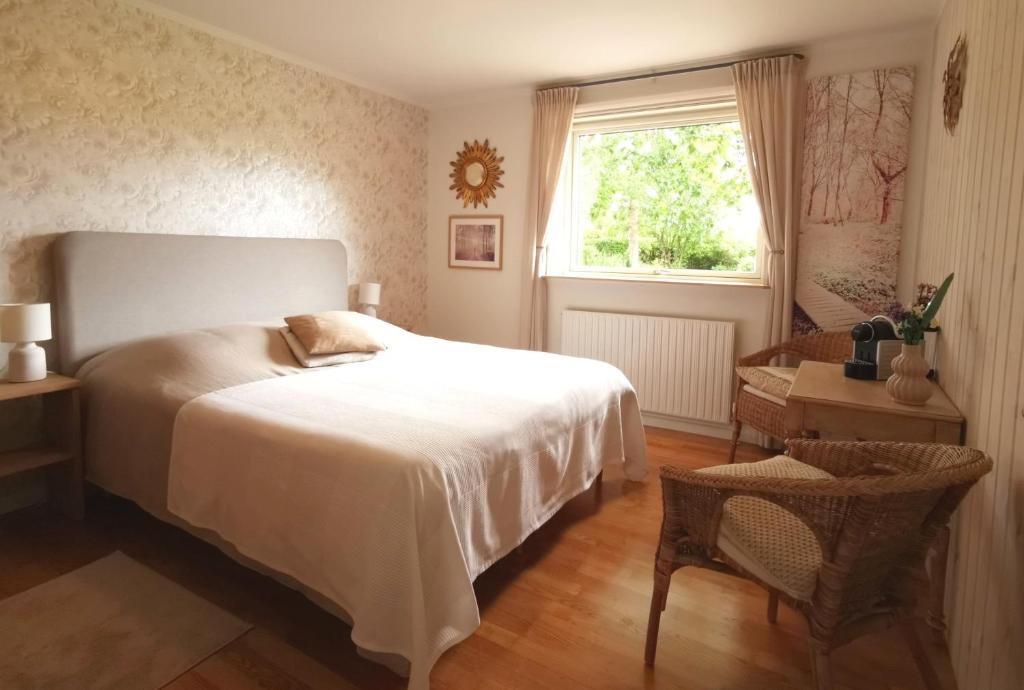 a bedroom with a bed and a window and a table at TheGilgahouse Gardenroom in Nakskov
