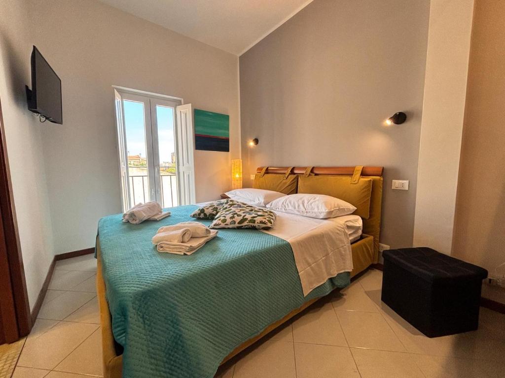 a bedroom with a bed with a blue blanket and a window at Teatro Massimo - Apartment with a View of Theater Massimo in Palermo