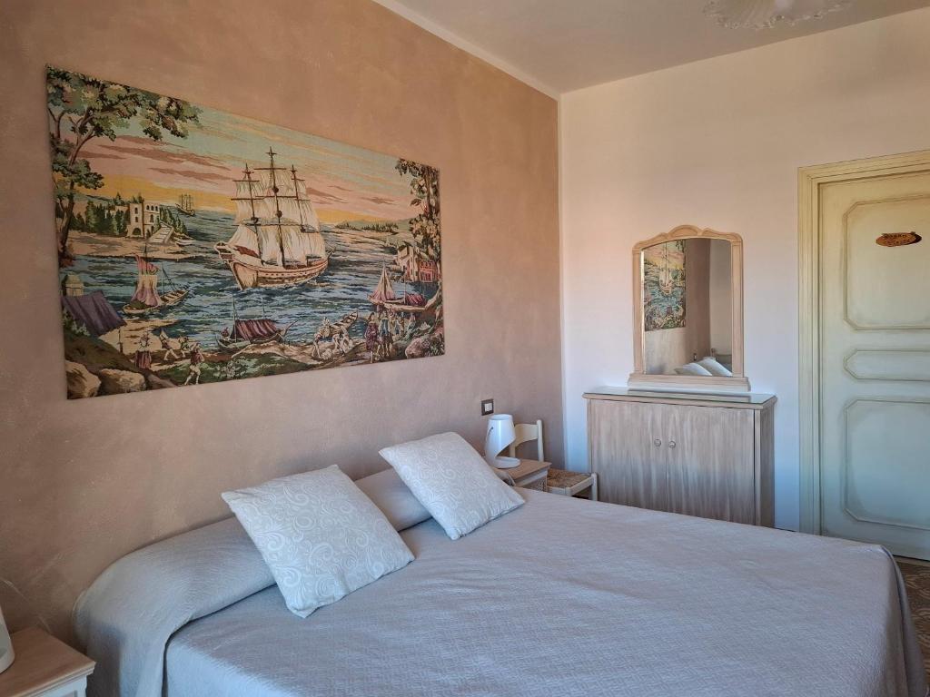 a bedroom with a bed with a painting on the wall at Da Ghjuannedda in Arzachena