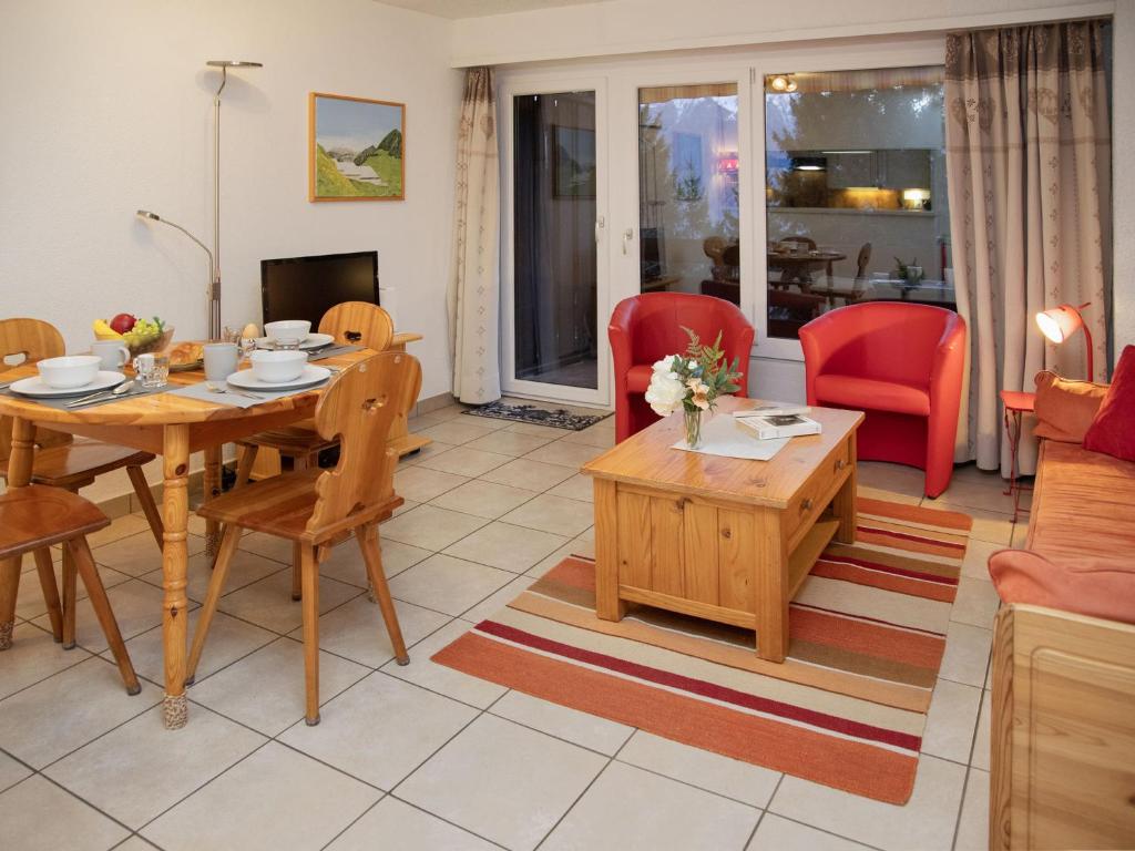 a living room with a table and chairs at Apartment Centaure B RS 2 by Interhome in Ovronnaz