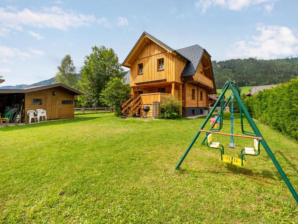 a swing in a yard in front of a house at Chalet Bergerlodge by Interhome in Schladming