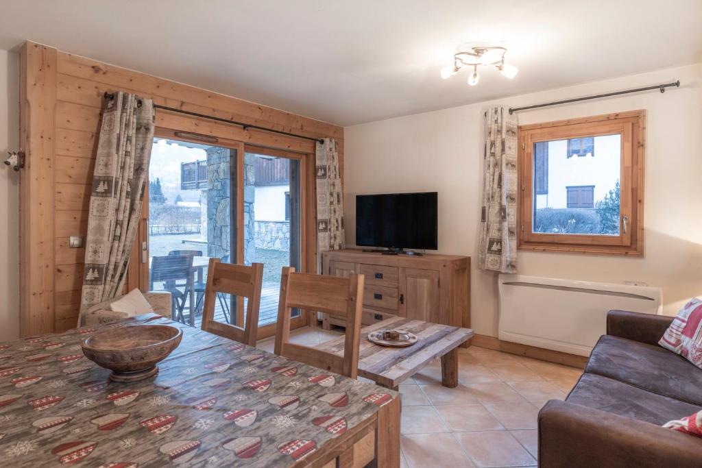 a living room with a couch and a table at App 6 pers cozy centre Samoëns in Samoëns