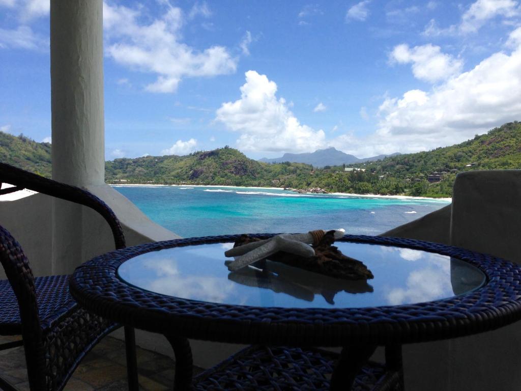 einen Tisch und Stühle mit Meerblick in der Unterkunft Lazare Picault Hotel in Baie Lazare, Insel Mahé