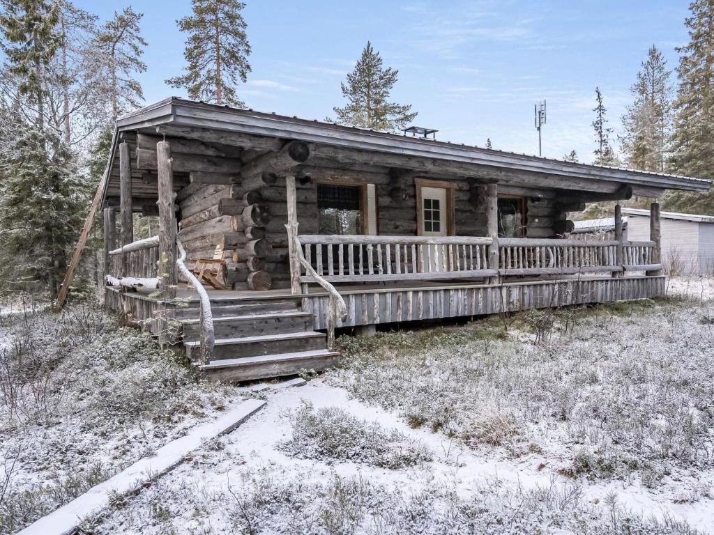 a log cabin with a porch in the snow at Holiday Home Pajalan honka by Interhome in Kuusamo
