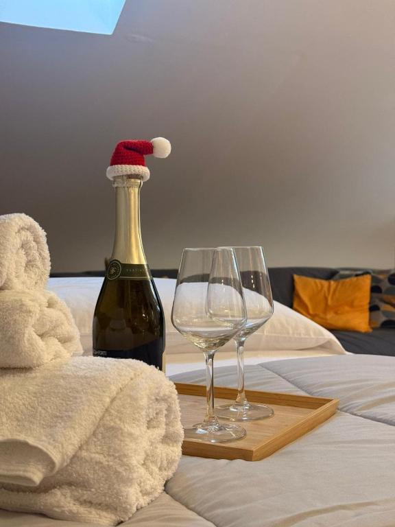 a bottle of wine and two glasses on a bed at Avigliana Einaudi in Avigliana