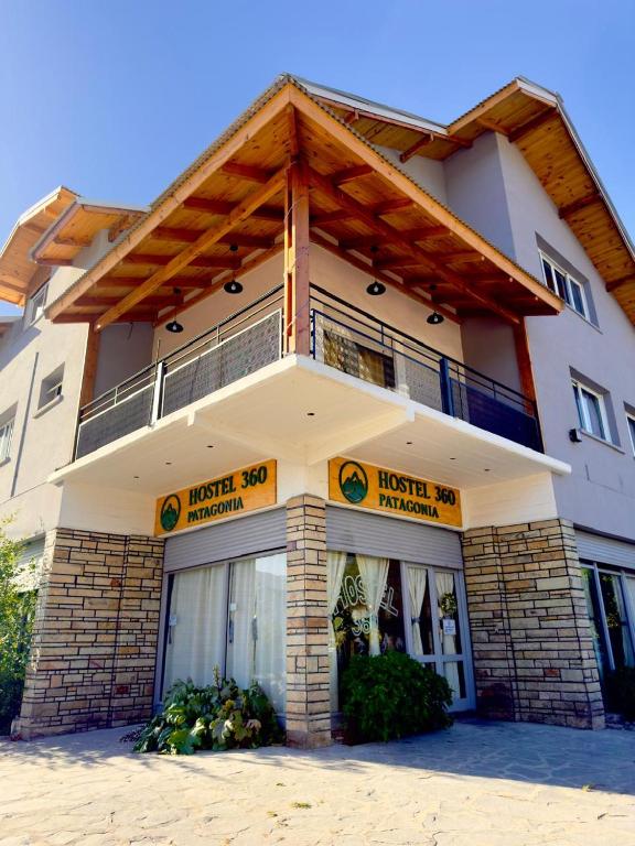 a building with a hotel sign in front of it at Hostel 360 Patagonia in El Bolsón