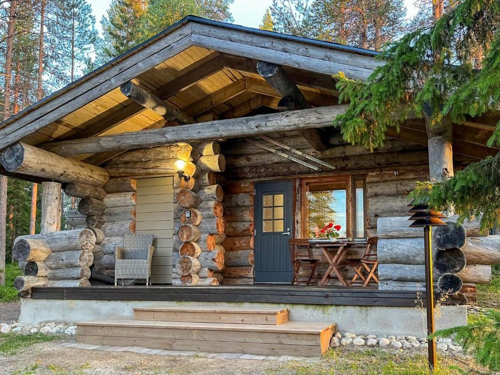 a log cabin in the woods with a porch and a door at Holiday Home Keloveska by Interhome in Ruka