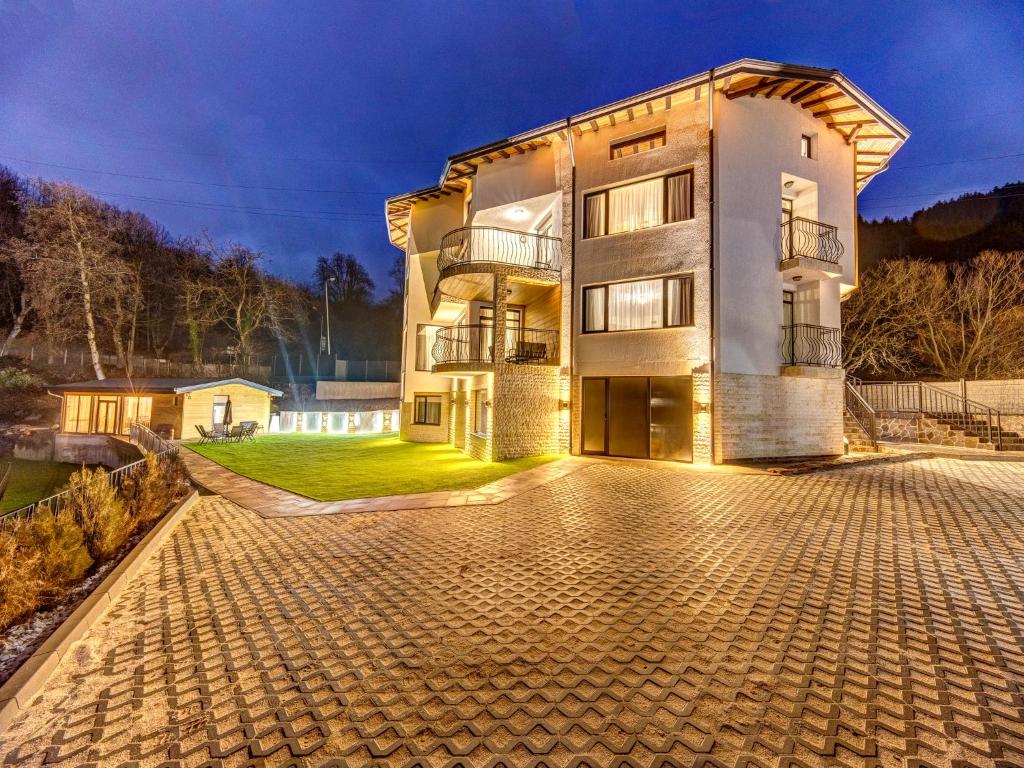 a house with a driveway in front of it at Къща за гости "Mirror Lake" in Smolyan