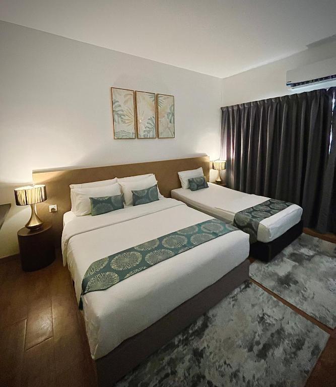 a hotel room with two beds and a window at Putri Hotel at Mydin Tunjong in Kota Bharu
