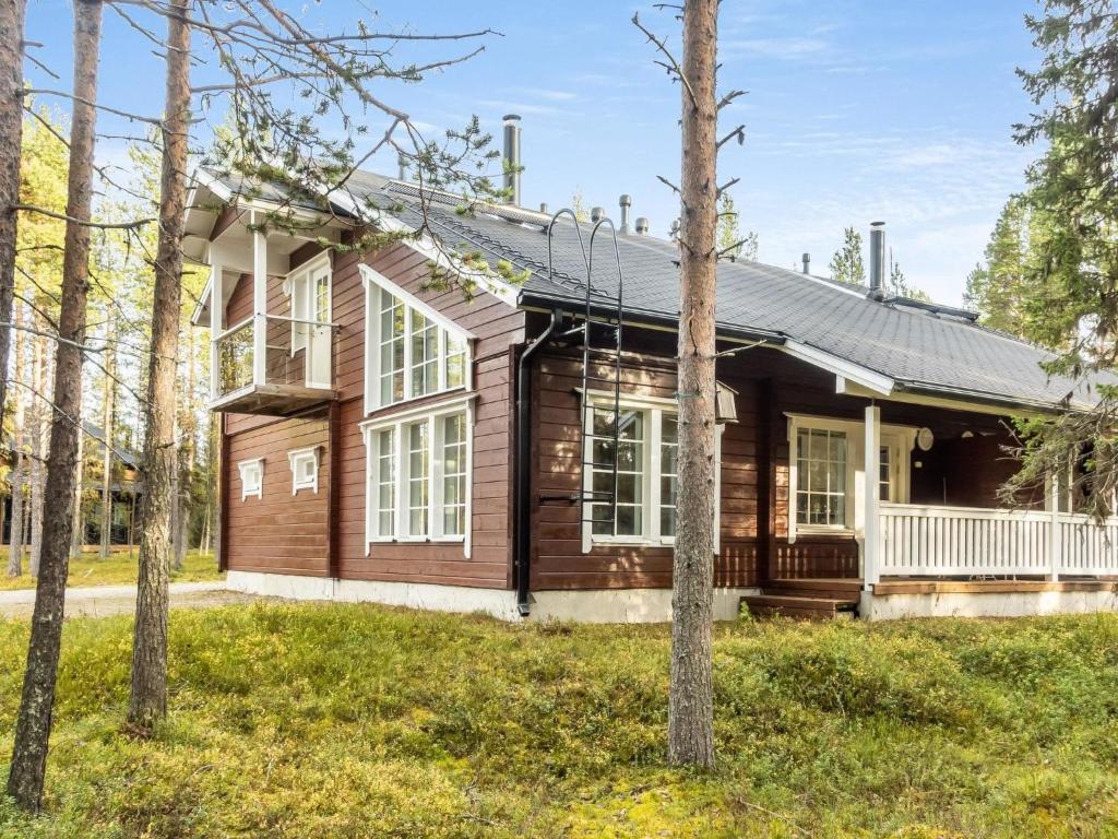 a wooden house in the woods with trees at Holiday Home Atrin suvanto a by Interhome in Levi