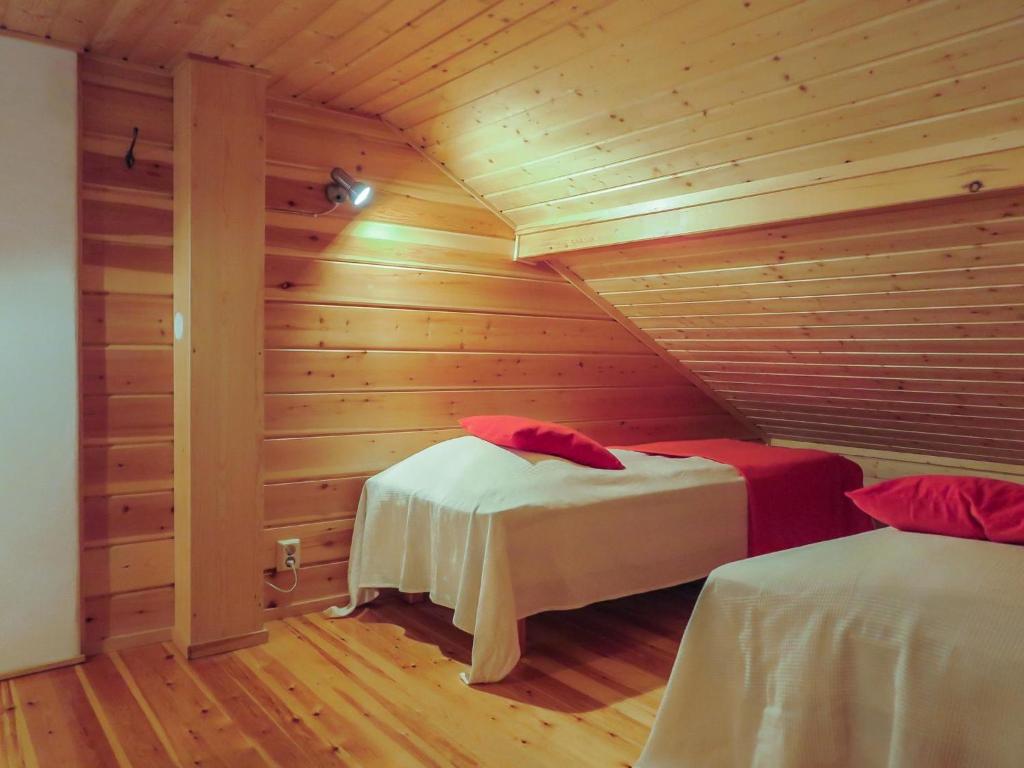 a room with two beds in a wooden room at Holiday Home Aslakit a by Interhome in Levi