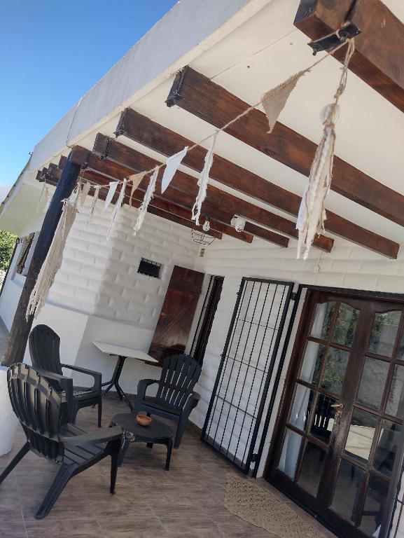 a patio with chairs and a table and a ceiling at Casita Tafí del Valle in Tafí del Valle