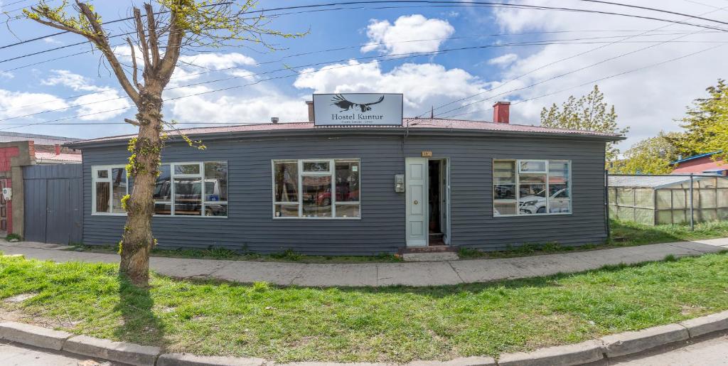 a blue building with a sign on top of it at Hostel Kuntur in Puerto Natales