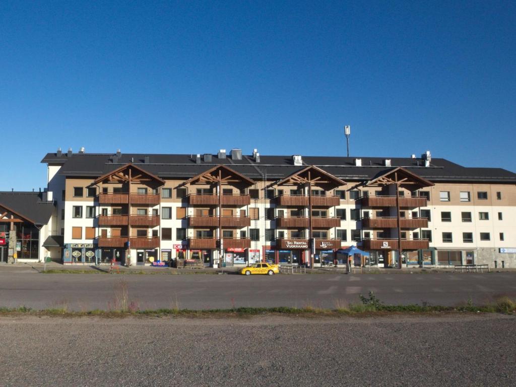 a large apartment building with a yellow car in front of it at Holiday Home Ski chalet 6206 by Interhome in Ylläs