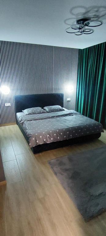 a bedroom with a bed with a green wall at The Nook in Sibiu