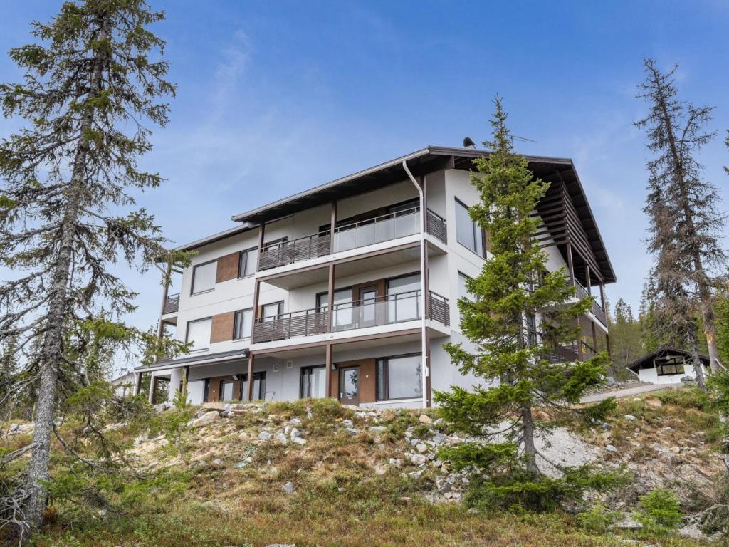 an apartment building on top of a hill with trees at Holiday Home Villa ylläs 101 by Interhome in Ylläs