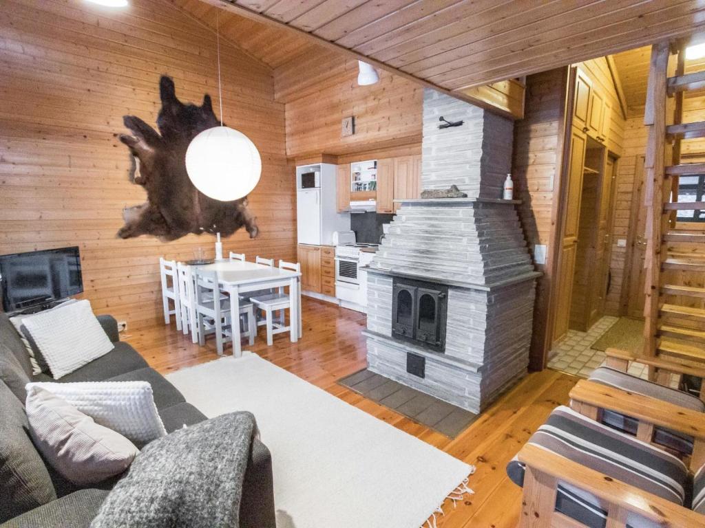 a living room with a couch and a fireplace at Holiday Home Ylläsrova b5 - kasku by Interhome in Ylläsjärvi