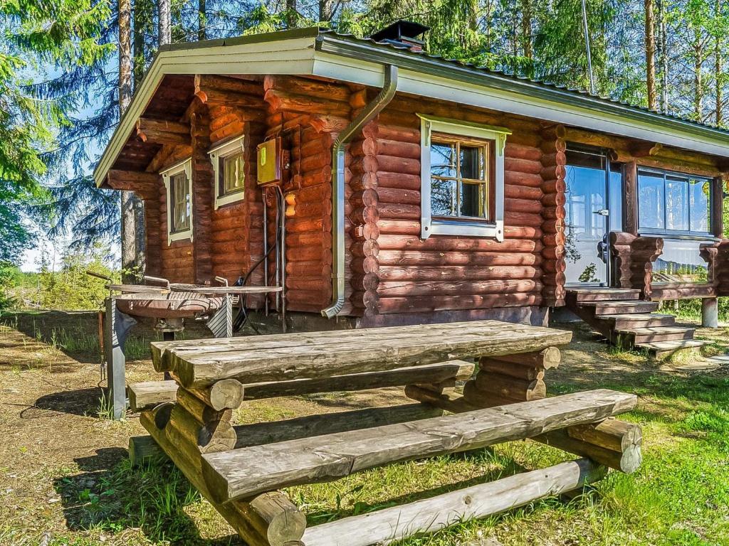 a log cabin with a bench in front of it at Holiday Home Huvilakoti 2 by Interhome in Puromäki