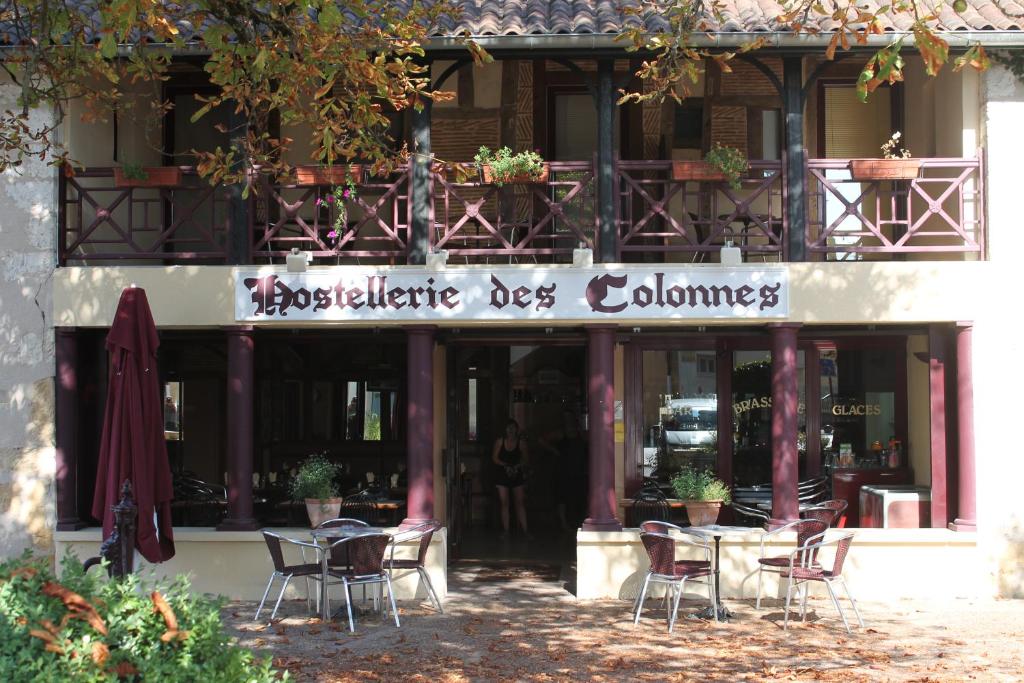 restauracja ze stołami i krzesłami przed budynkiem w obiekcie Hostellerie des Colonnes w mieście La Force