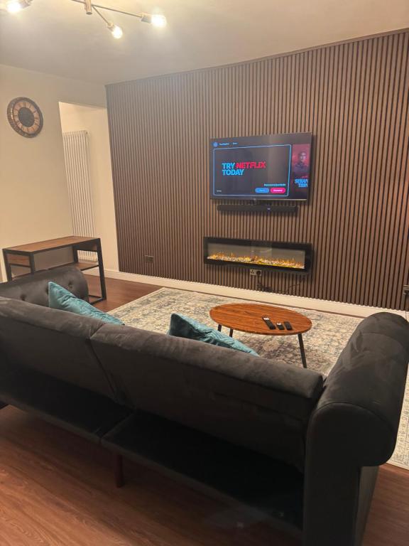a living room with a couch and a flat screen tv at Timeless Spacious 1bedroom Duplex apartment with balcony in Shoreditch in London