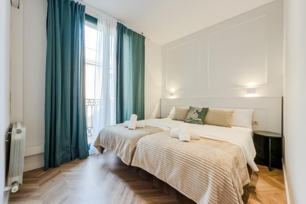 a bedroom with two beds and a large window at Palau de la Musica Apartments in Barcelona