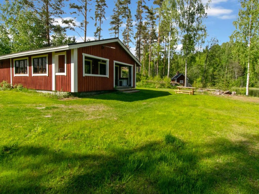 a small red house in the middle of a yard at Holiday Home 21 by Interhome in Varparanta