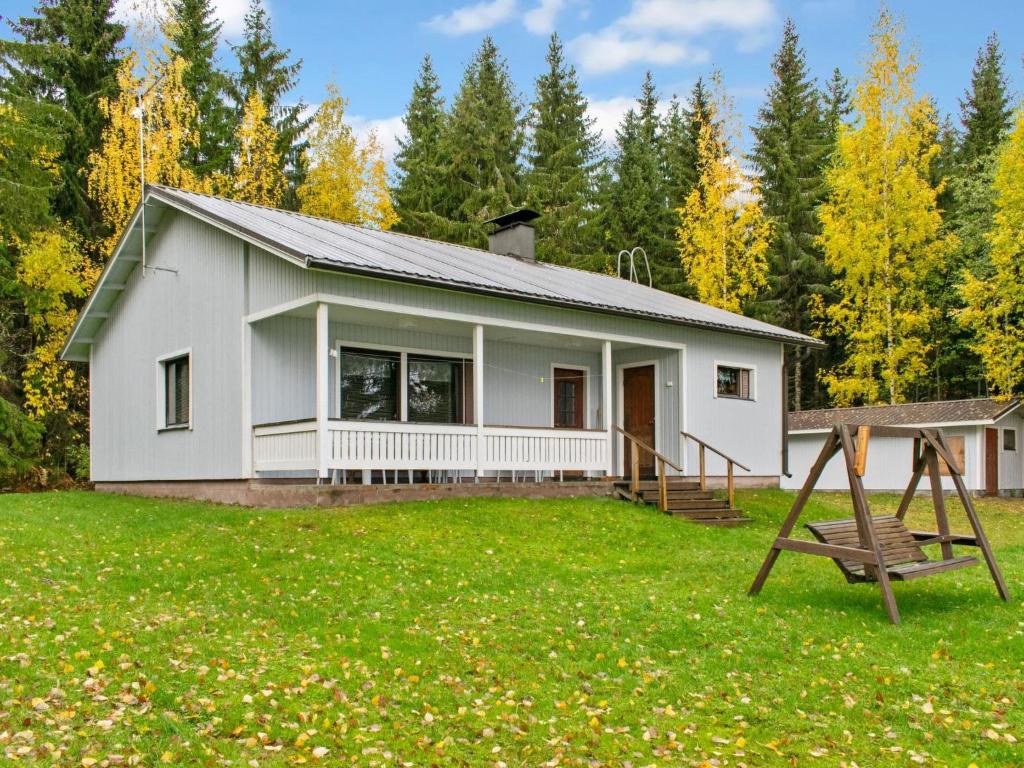 a white house with a playground in the yard at Holiday Home Lomaranta by Interhome in Ruvaslahti