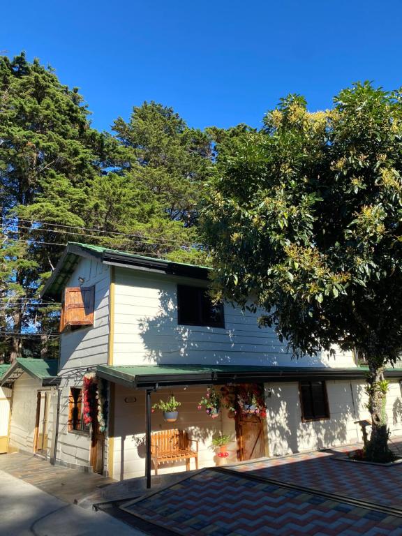 a white house with a green awning on it at Cabañas Tierra Fertil in Montaña