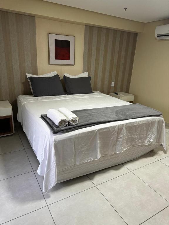 a large bed with two towels on top of it at Flat no Vivence Suites em Palmas in Palmas