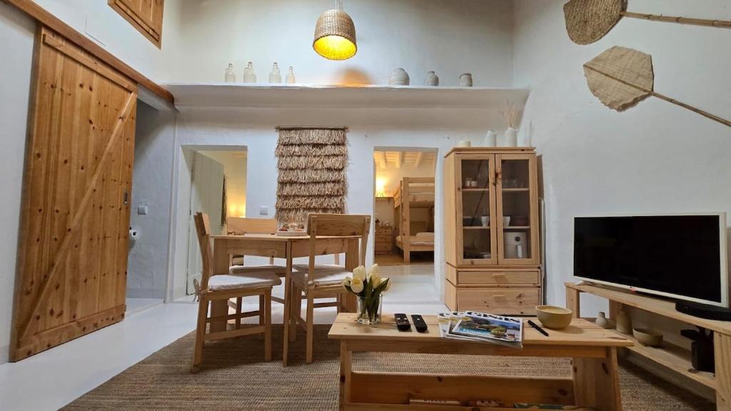 a living room with a table and a television at Casa do Castelo Terena in Alandroal