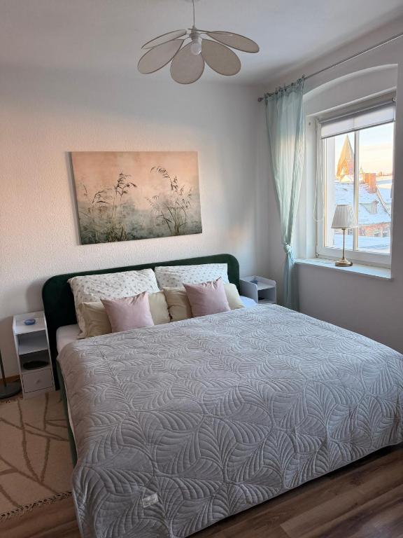 a bedroom with a large bed and a window at Luisen City Studio Görlitz in Görlitz