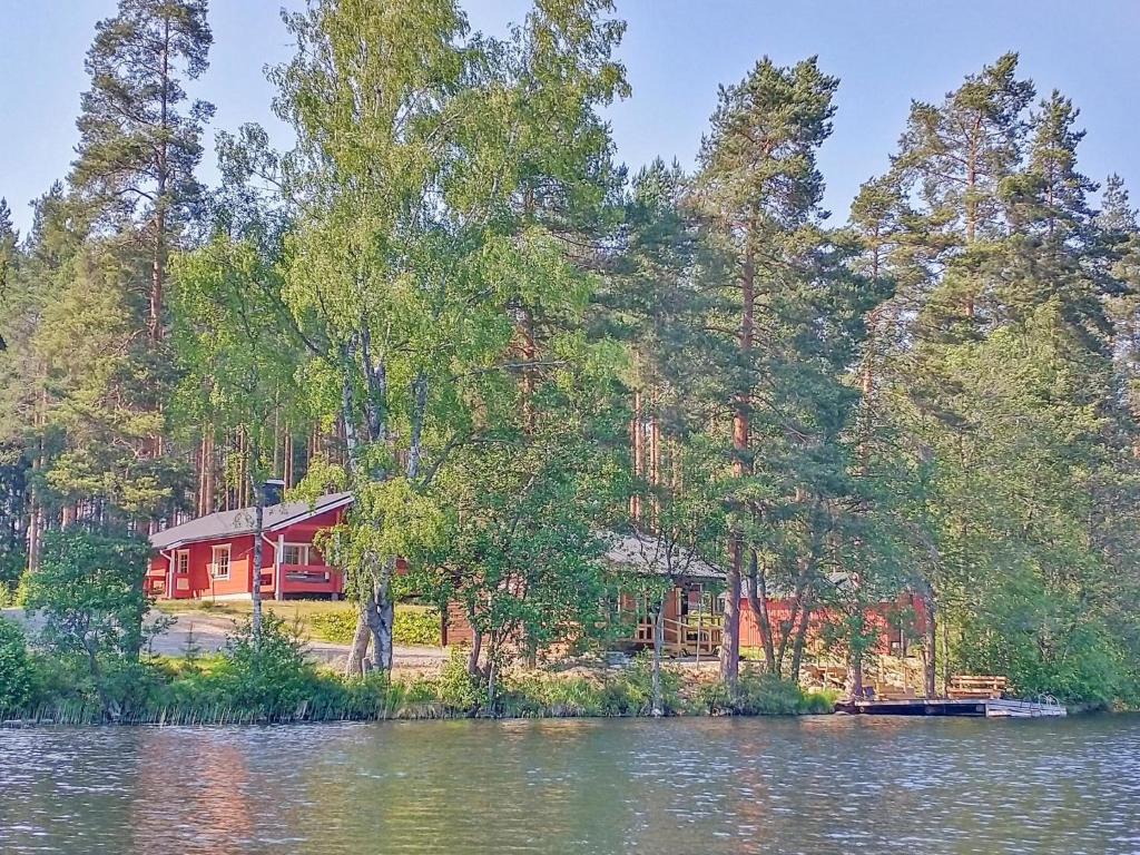a red house on the shore of a lake at Holiday Home Hankamaja by Interhome in Ihamaniemi